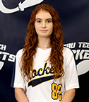 female with long red hair wearing a softball jersey