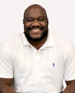 Man wearing a white polo and smiling